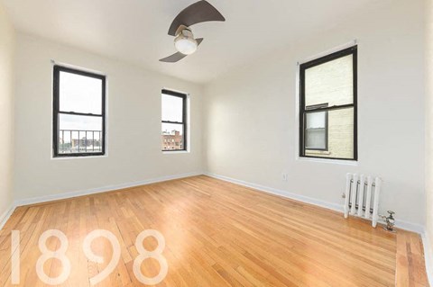 A room with wooden floors and two windows.