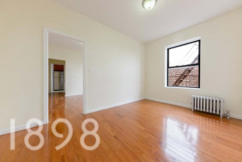 A room with a window and a radiator on the floor.