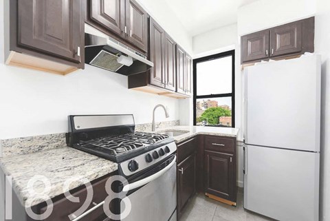 A kitchen with a stove top oven and a refrigerator.