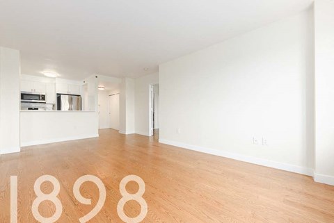 A room with wooden floors and white walls, with the number 1898 on the floor.