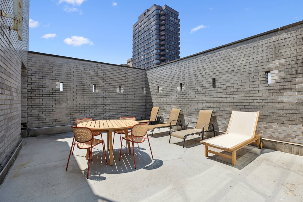A patio with a table and chairs is surrounded by brick walls.