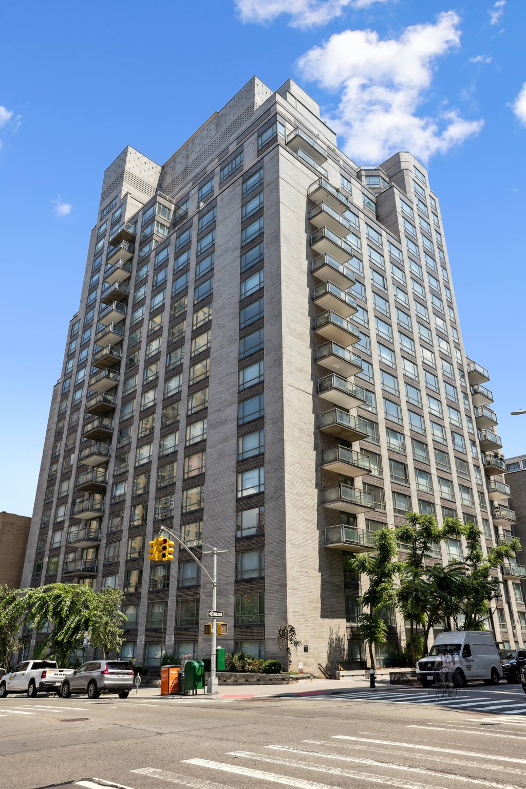 A tall building with many windows is located on a street corner.