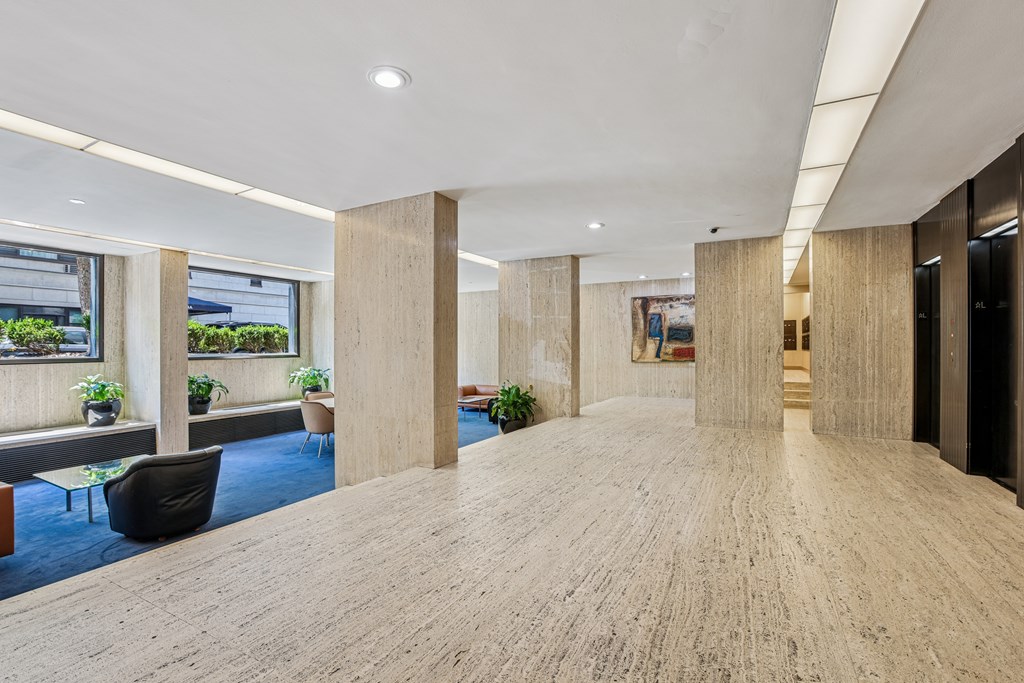 A spacious office hallway with wooden floors and columns.