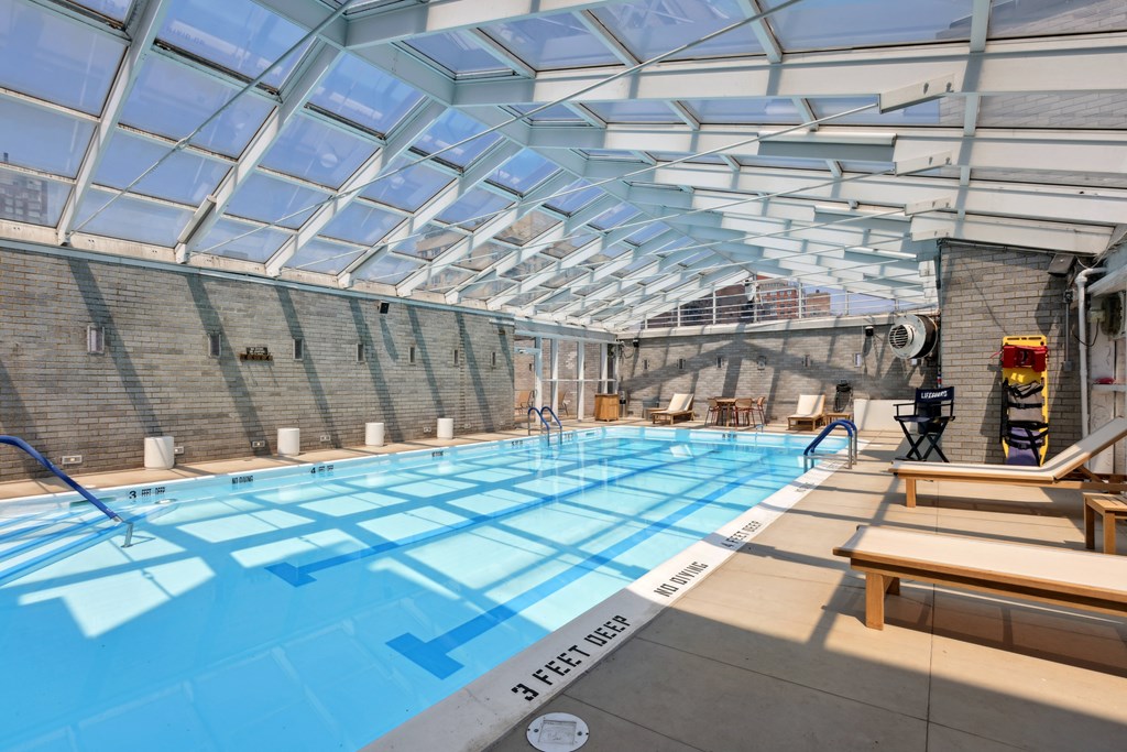 A swimming pool with a glass ceiling and a 3 feet deep sign.