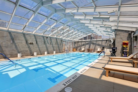 A swimming pool with a glass ceiling and a 3 feet deep sign.