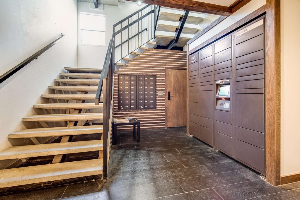 a staircase leading up to a hallway with a wooden door and stairs
