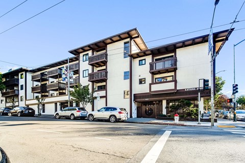 an empty street with cars parked in front of an apartment building