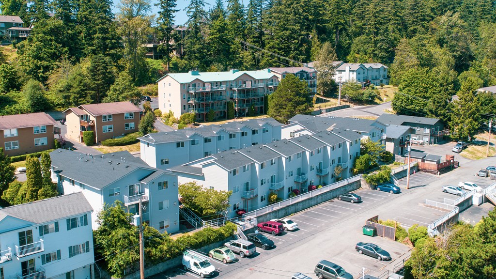an aerial view of apartments and cars in a parking lot