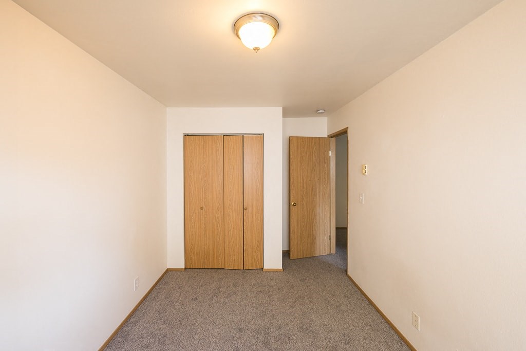a bedroom with a closet and a door to a hallway