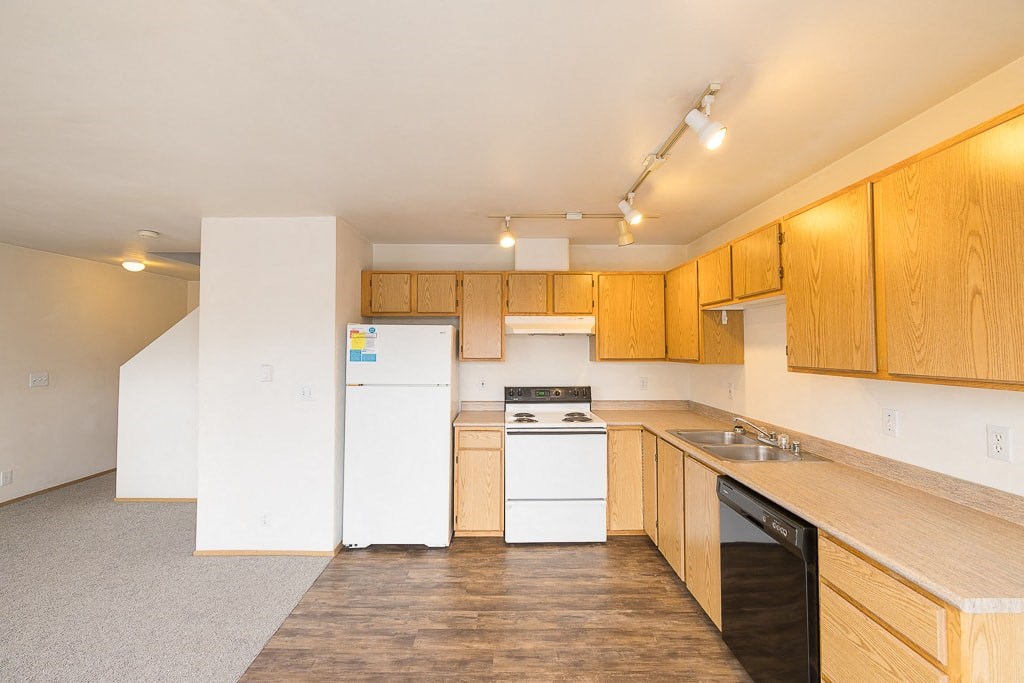 a kitchen with white appliances and wooden cabinets