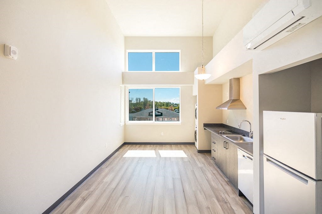 an empty room with a kitchen and a window