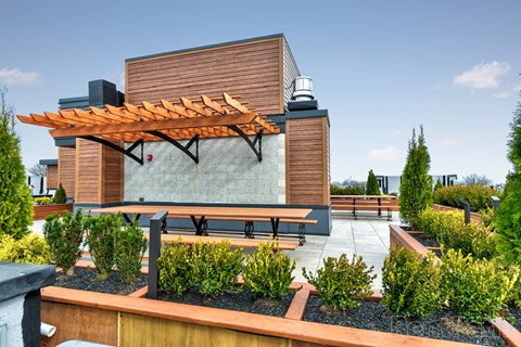 a patio with a bench and a pavilion with a building in the background