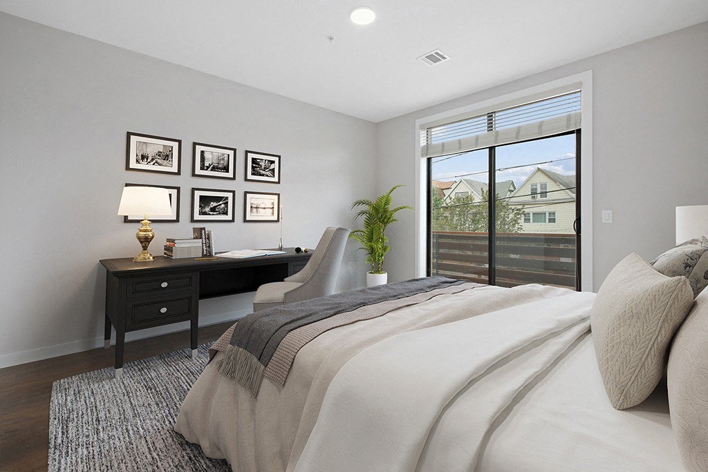 a bedroom with a bed and a desk and a window