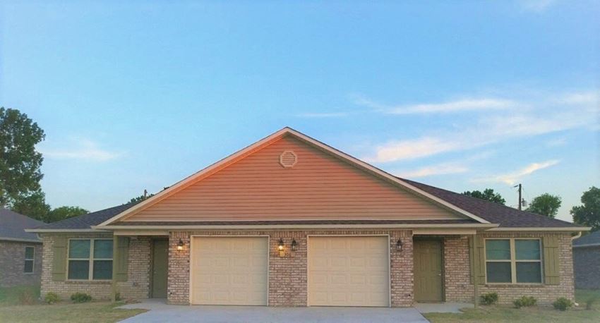 a brick house with two garage doors