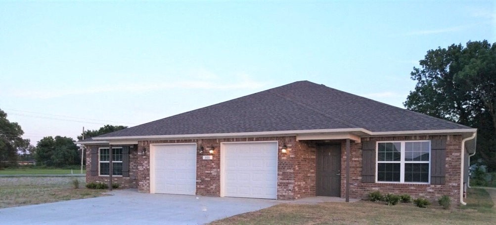 a brick house with two white garage doors