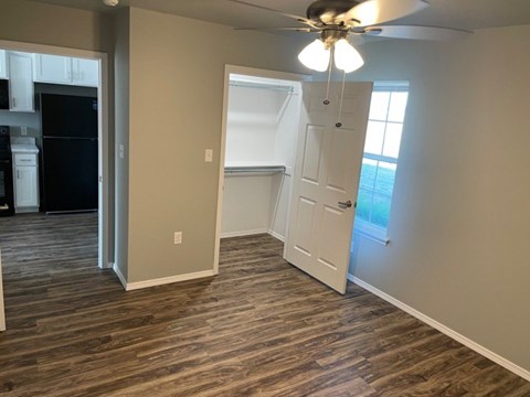 A room with a ceiling fan and a door leading to a balcony.