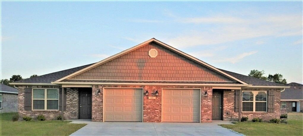 a brick house with two garage doors