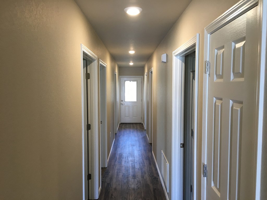 a hallway with wooden floors and white doors