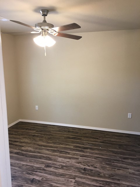 a living room with a ceiling fan and wood floors
