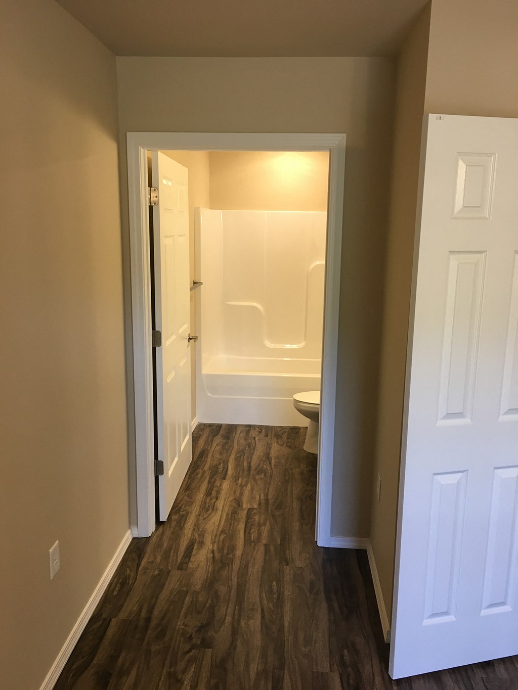 a bedroom with a door open to a bathroom with a toilet