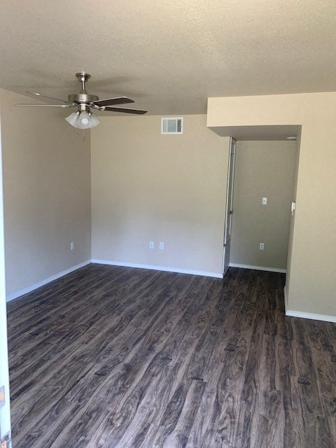 an empty room with a ceiling fan and a door