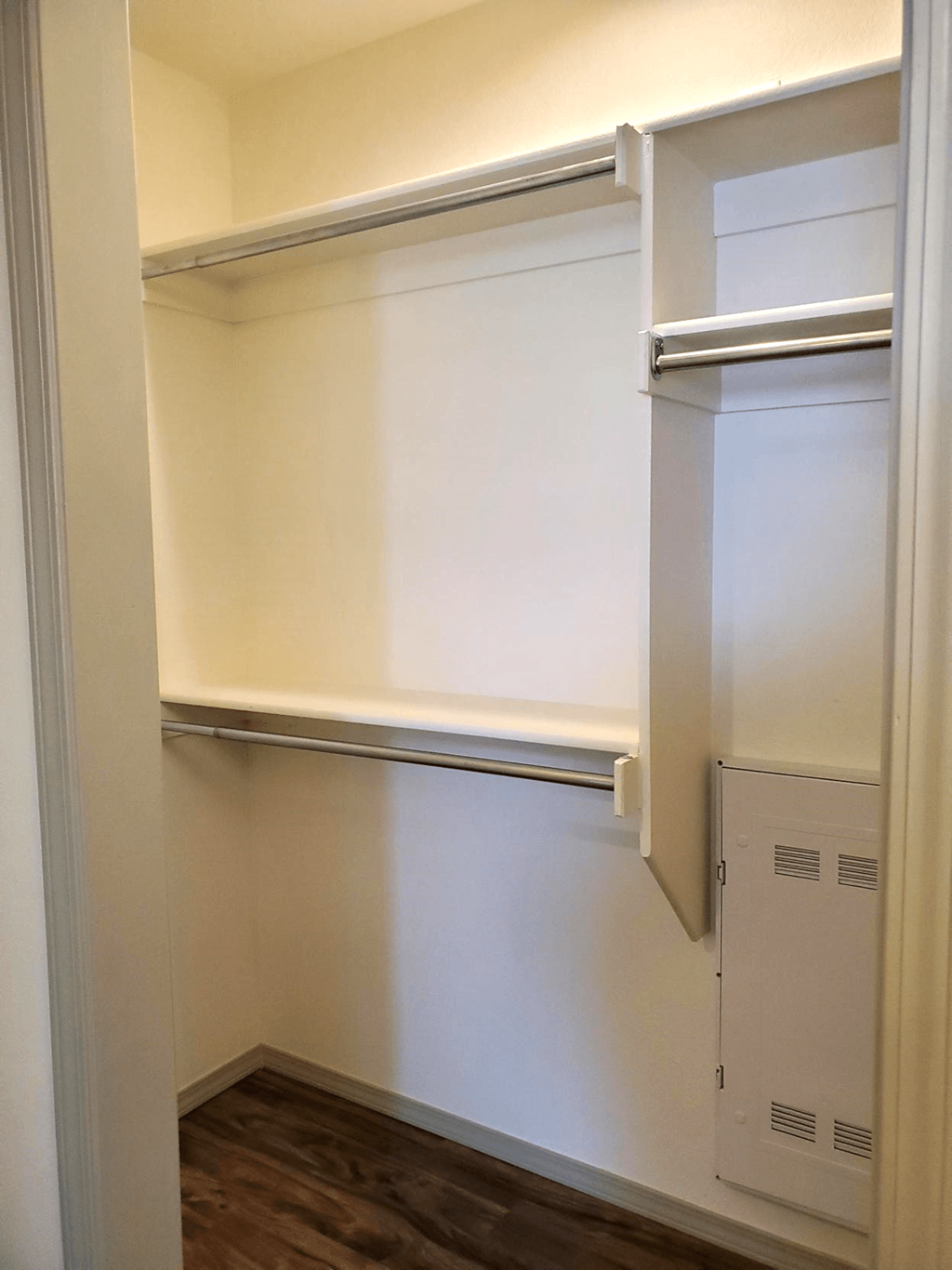 a walk in closet in a home with white walls and a white