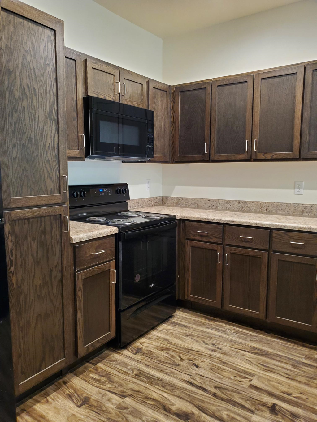a kitchen with black appliances and wooden cabinets