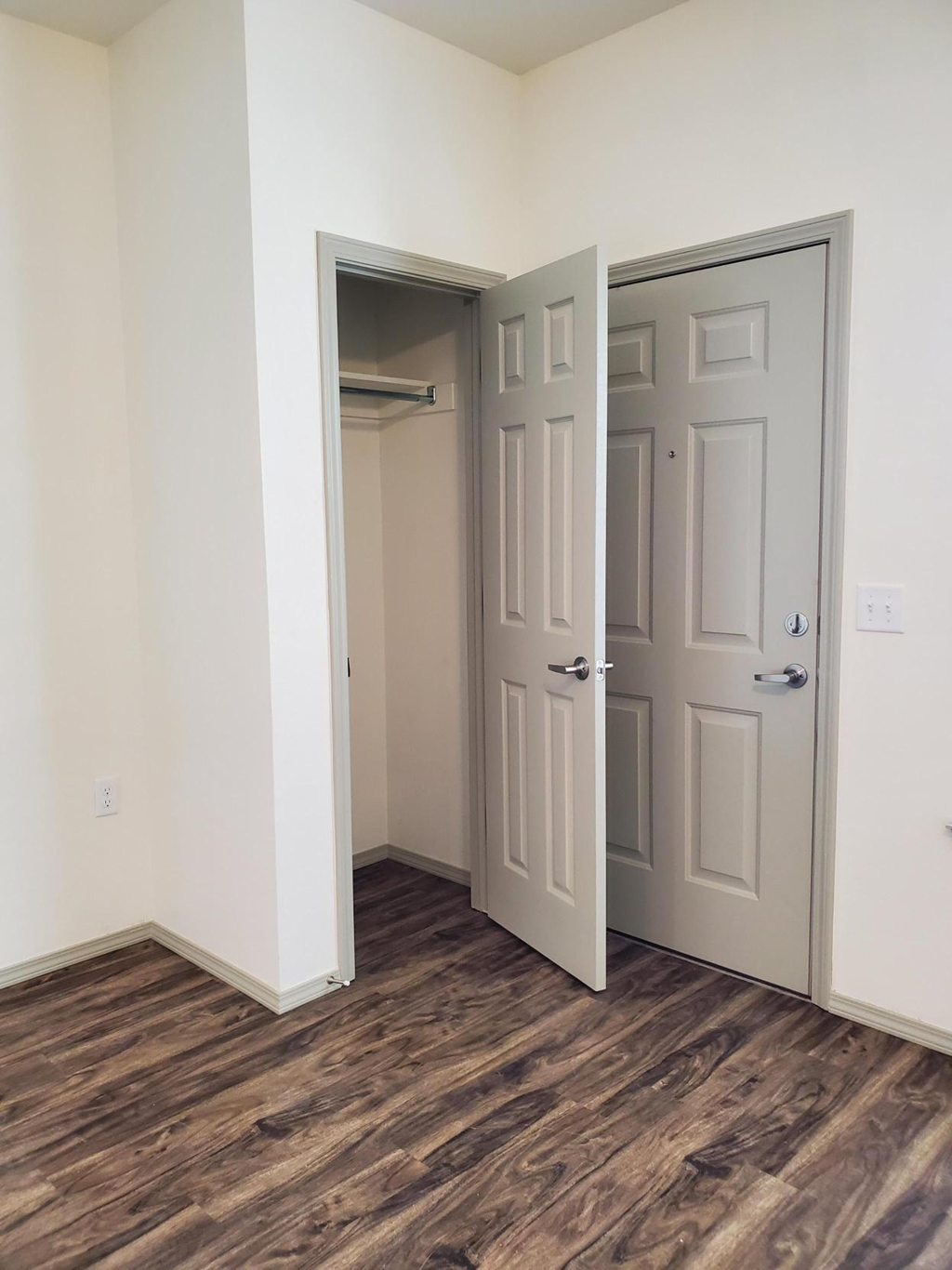 an empty room with two doors and a closet