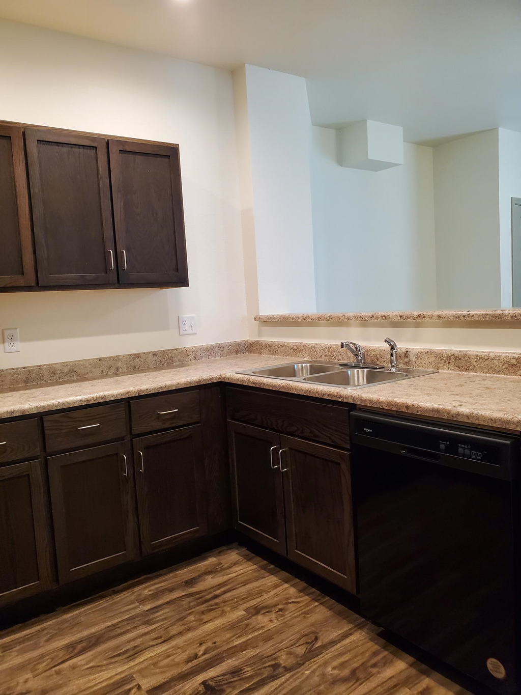 a kitchen with dark wood cabinets and a sink