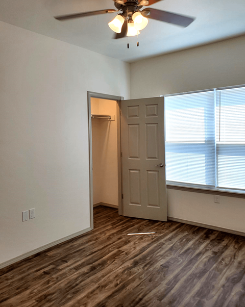 a bedroom with a door and a ceiling fan