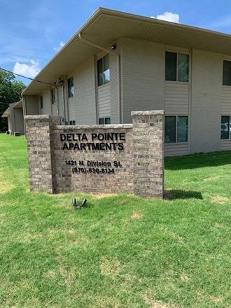 a sign for delta point apartments in front of a building