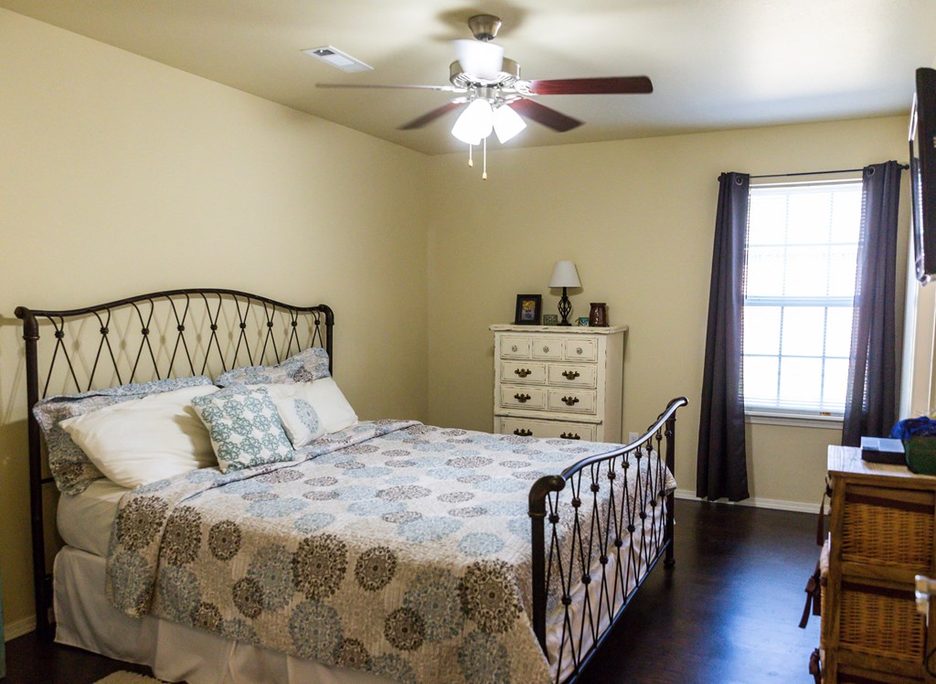 a bedroom with a bed and a ceiling fan