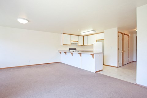 the living room and kitchen of an empty apartment