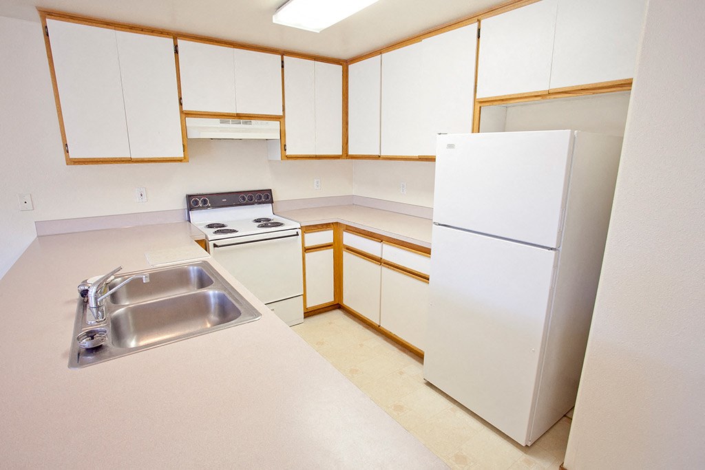 a kitchen with white cabinets and a sink and a refrigerator
