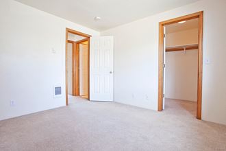 a bedroom with a carpeted floor and a closet
