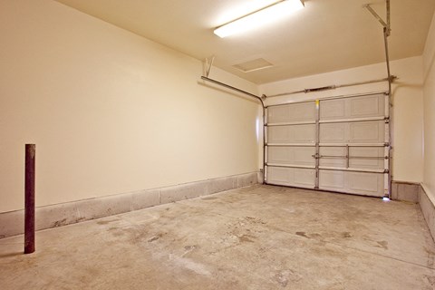 an empty garage with white walls and a garage door