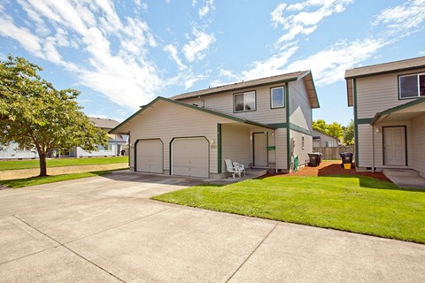 a driveway in front of a house with a lawn