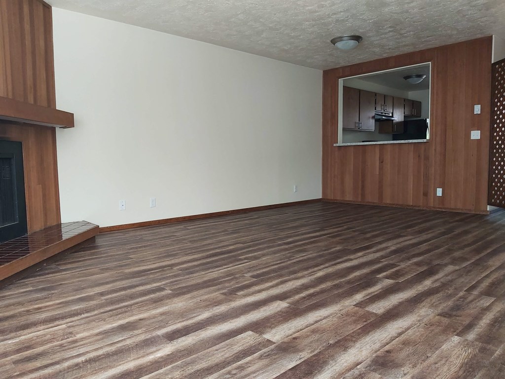 a living room with a fireplace and wooden floors
