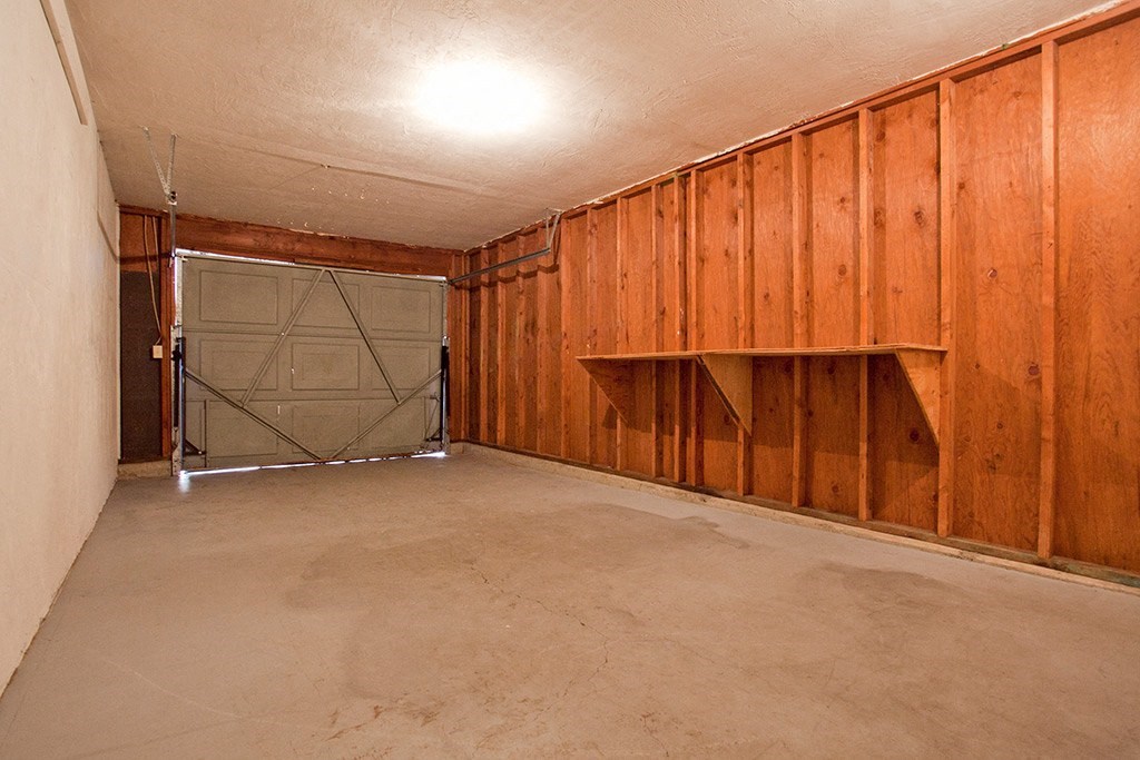 a garage with wood paneled walls and a garage door