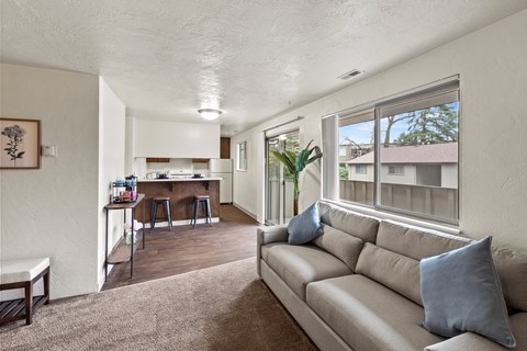 A living room with a couch and a bar area in the background.
