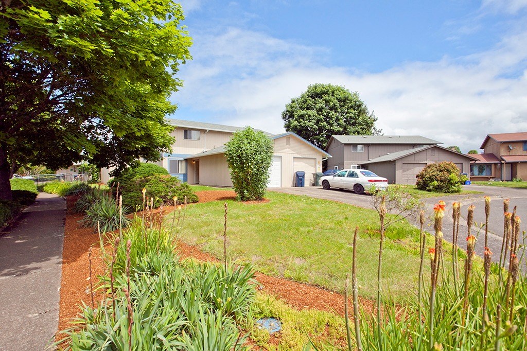 a house with a yard and a car parked in front of it