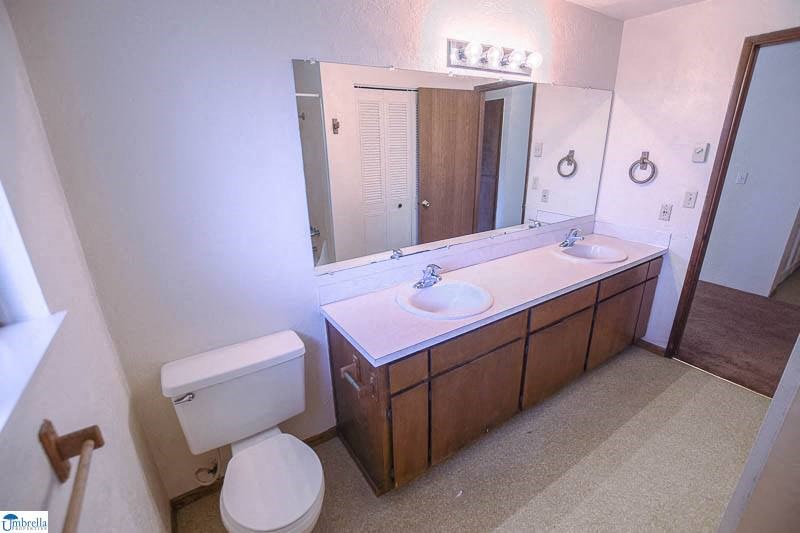 a bathroom with a toilet a sink and a mirror