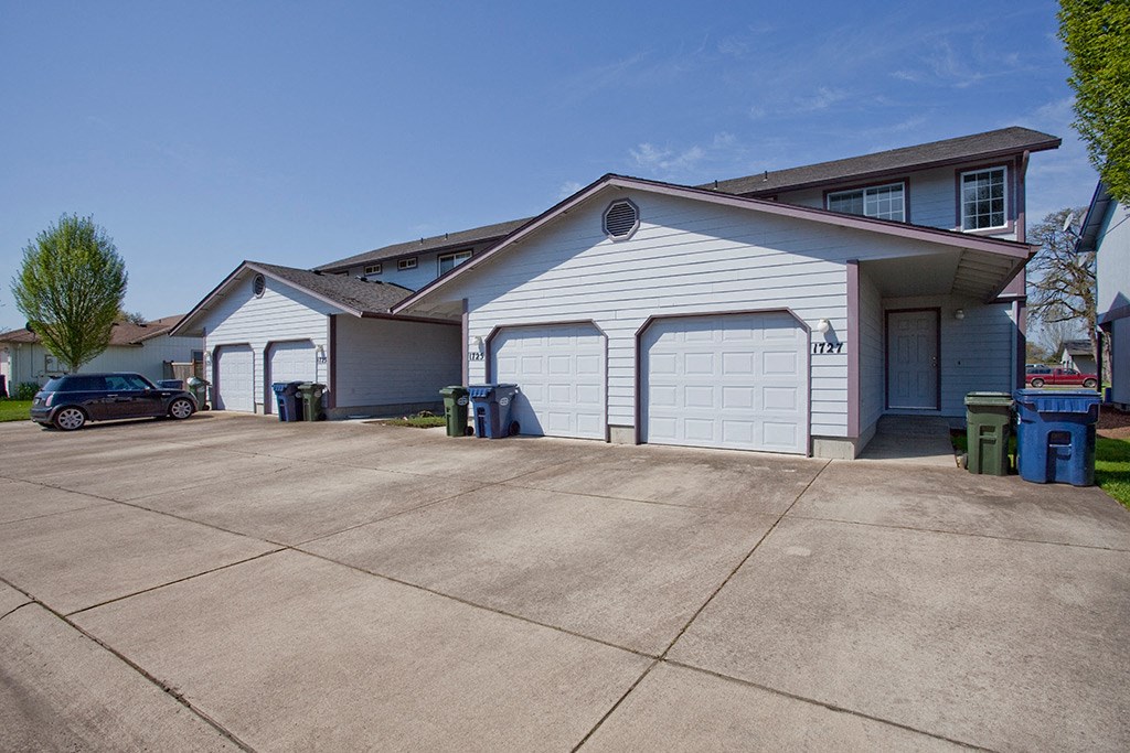 a white garage with a driveway in front of a house