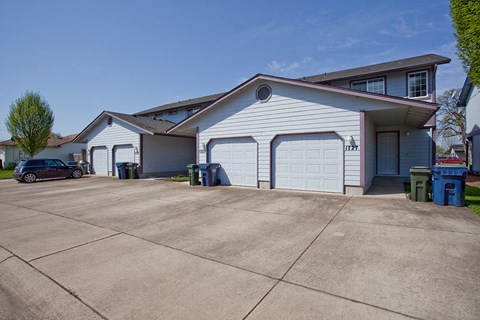 a white garage with a driveway in front of a house