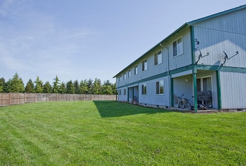 a blue barn with a grassy yard in front of it