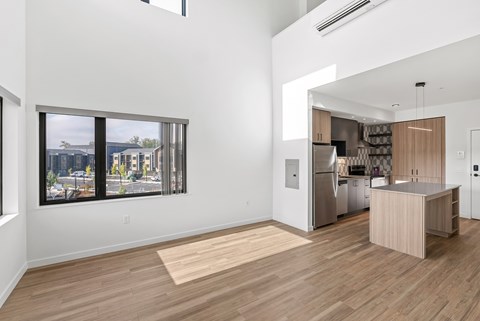 A kitchen with wooden floors and a view of the city through the windows.