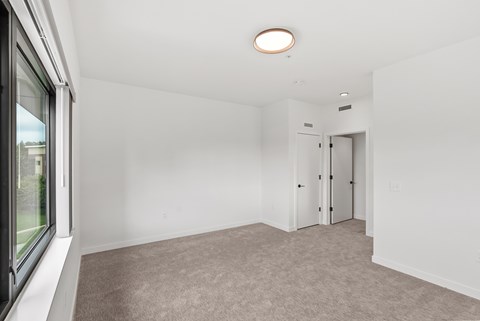 A room with a carpeted floor and a ceiling light.