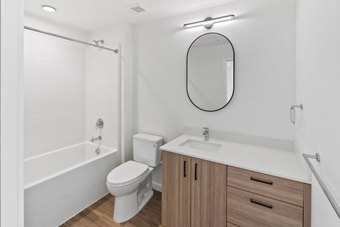 A white bathroom with a toilet, sink, and bathtub.