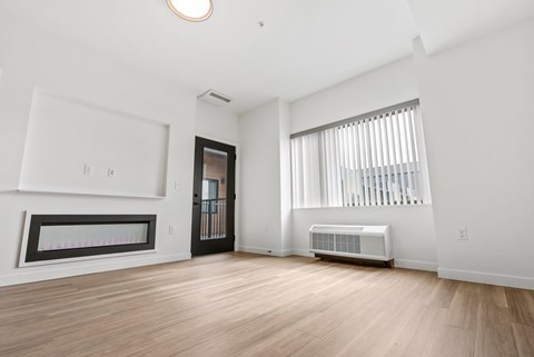 A spacious room with a window, a door, and a radiator.