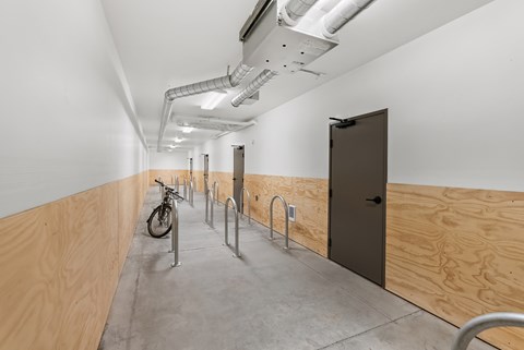 A long hallway with a bicycle and a door at the end.